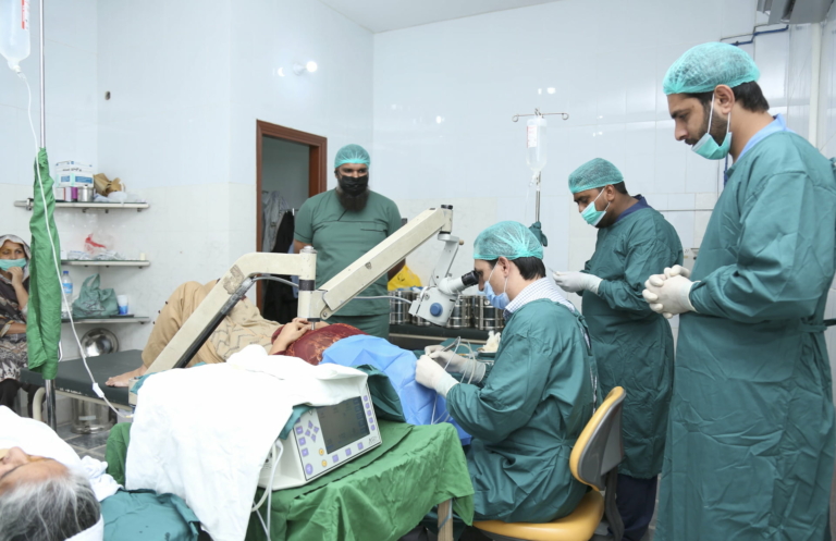 Surgeons gathered around performing a cataract surgery