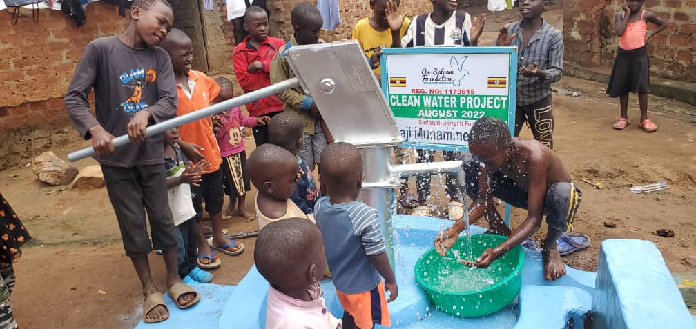 Children enjoying fresh clean water from a hand pump well in Uganda