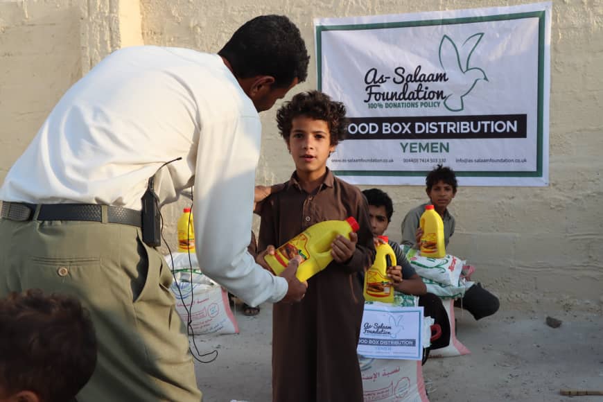 A young boy receiving his food box distribution in Yemen
