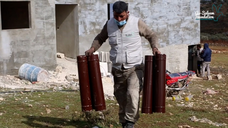 A volunteer carrying gas heaters for a warmth project