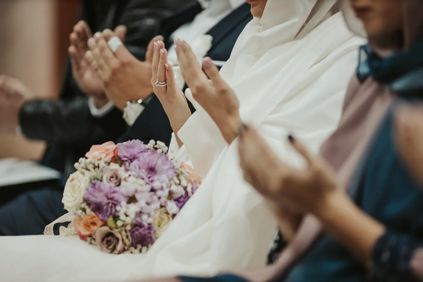 Muslim woman and muslim groom both raising hands to make dua after being married
