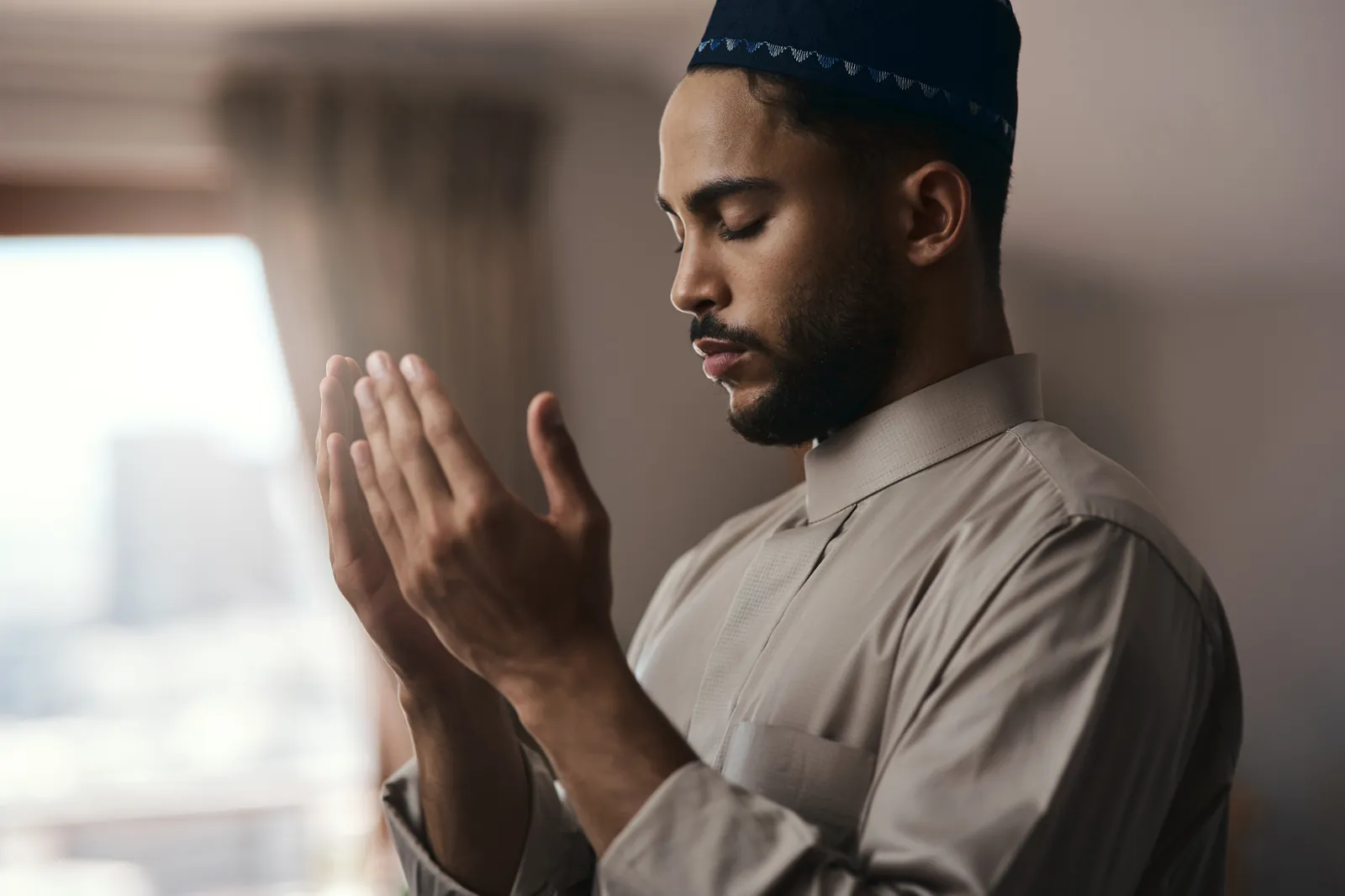 How to Pray the Janazah Prayer 3 Muslim man with eyes closed and hands raised in dua